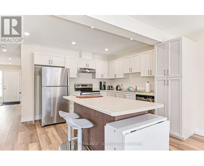 A kitchen with white cabinets and a wooden island.
