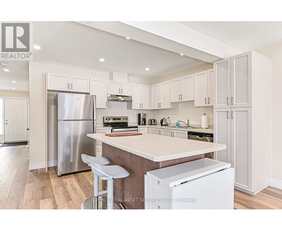A kitchen with white cabinets and a wooden island.