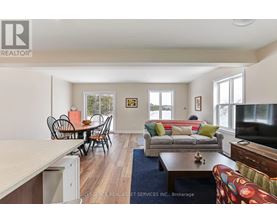 A living room with a couch, chairs, and a television.