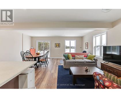 A living room with a couch, chairs, and a television.
