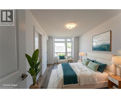 A bedroom with a bed, nightstand, and a plant.