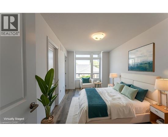 A bedroom with a bed, nightstand, and a plant.