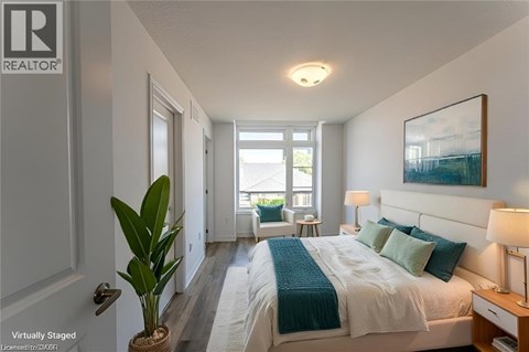 A bedroom with a bed, nightstand, and a plant.