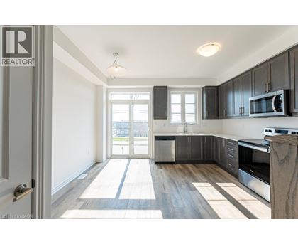A well-lit kitchen with dark wood cabinets and a white door.