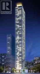 A tall building with a lit up top and the logo REALTOR on the top left.