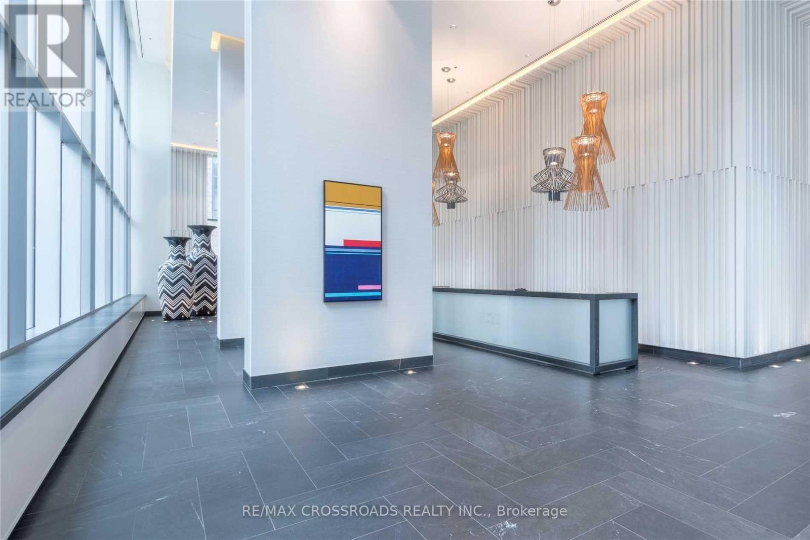 A reception area with a white reception desk and a blue and red sign on the wall.