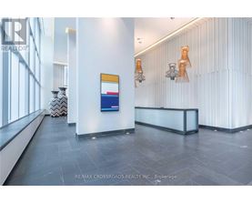 A reception area with a white reception desk and a blue and red sign on the wall.