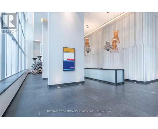 A reception area with a white reception desk and a blue and red sign on the wall.
