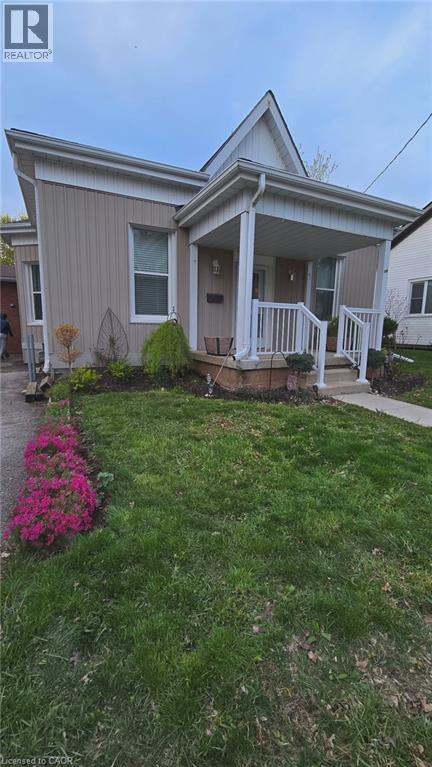 A house with a well-kept lawn and a flower bed in front.