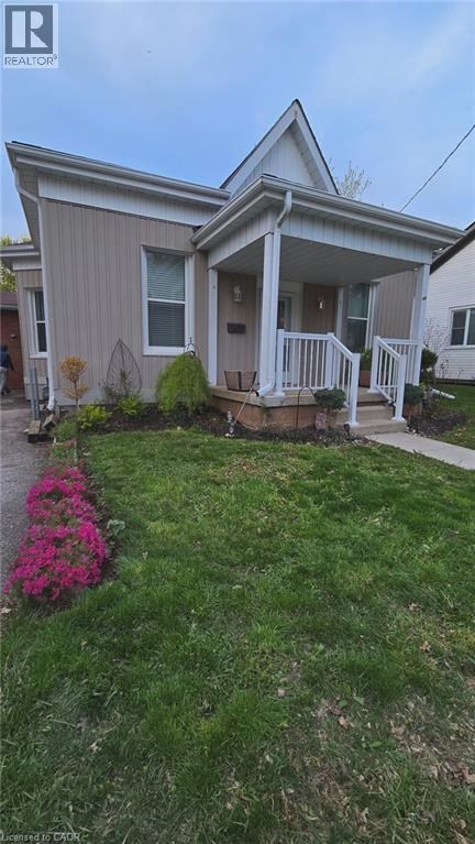 A house with a well-kept lawn and a flower bed in front.