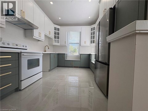 A modern kitchen with white cabinets and stainless steel appliances.