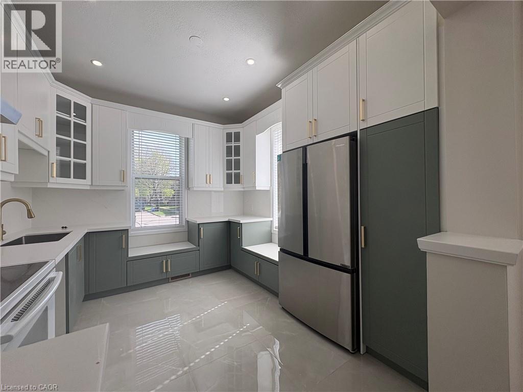A kitchen with white cabinets and a black fridge.