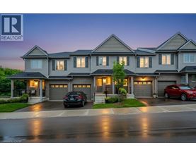 A large, modern house with a realtor logo in the corner.