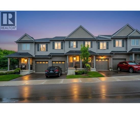 A large, modern house with a realtor logo in the corner.