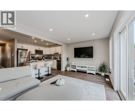 A modern living room with a grey sofa and a television on the wall.