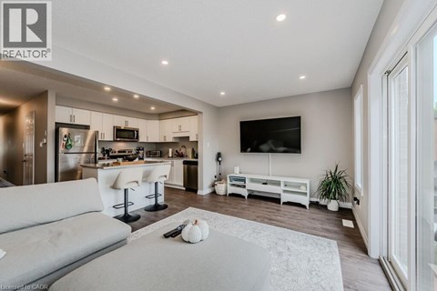 A modern living room with a grey sofa and a television on the wall.