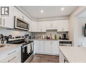 A modern kitchen with white cabinets and stainless steel appliances.