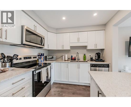 A modern kitchen with white cabinets and stainless steel appliances.