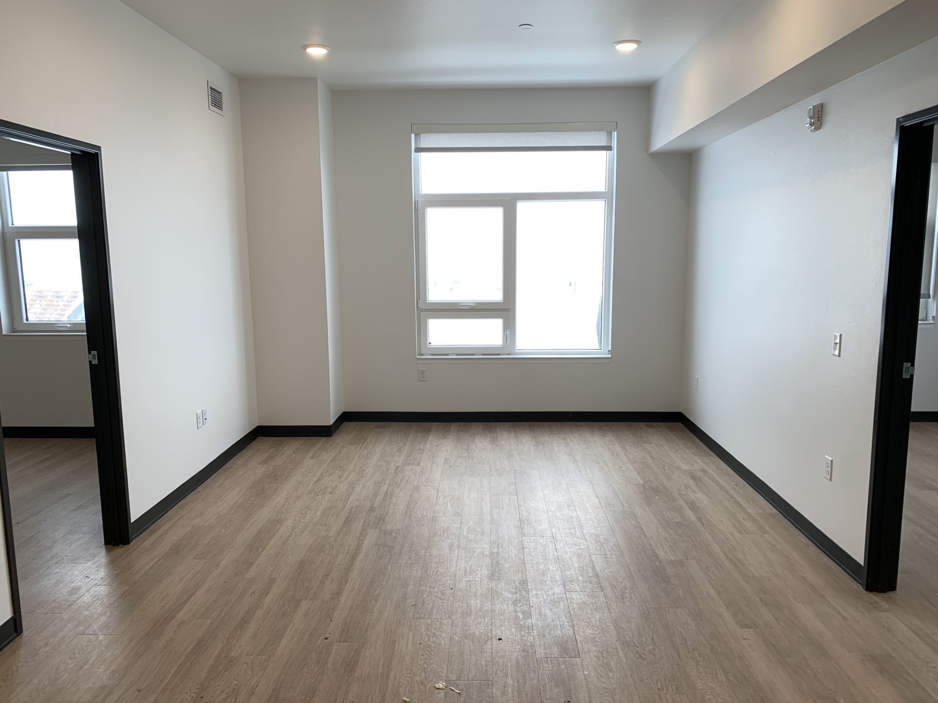 A room with a window and wooden flooring.