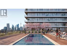 A swimming pool with people relaxing by it in front of a building.
