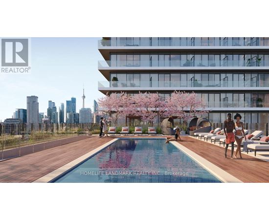 A swimming pool with people relaxing by it in front of a building.