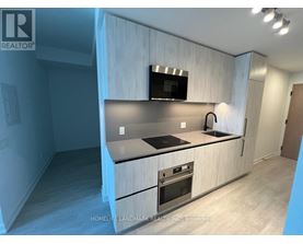 A modern kitchen with a wooden cabinet and stainless steel appliances.