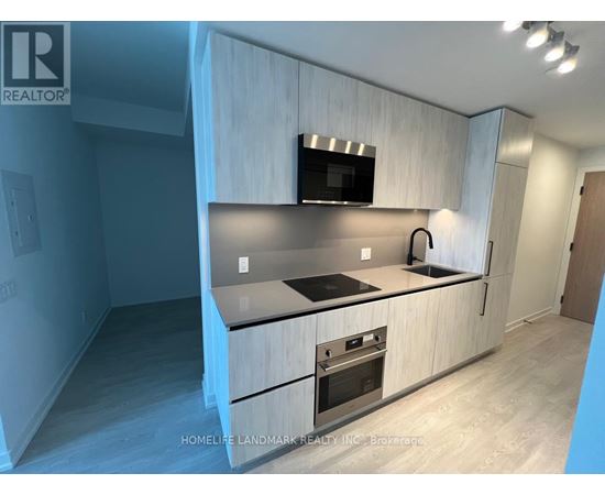 A modern kitchen with a wooden cabinet and stainless steel appliances.