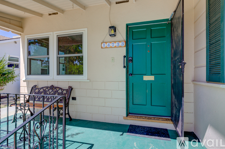 A green door is on the right side of a white wall.