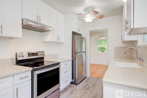 A kitchen with white cabinets and a stainless steel refrigerator.
