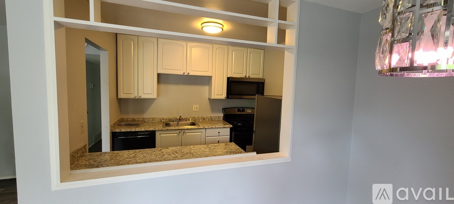 A kitchen with white cabinets and a black stove top oven.