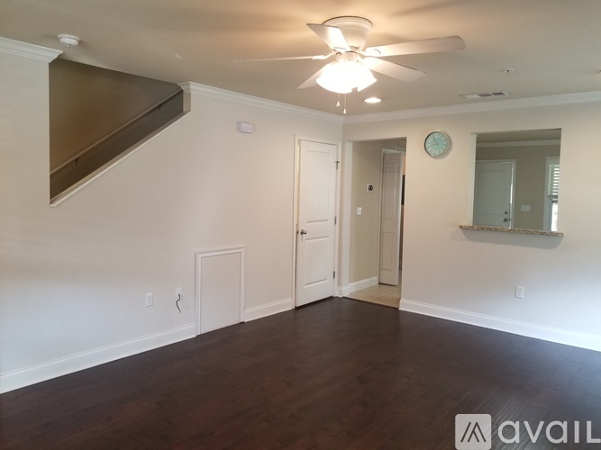 A spacious room with a ceiling fan and wooden flooring.
