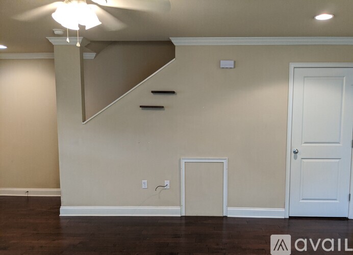 A room with a white door and a staircase.