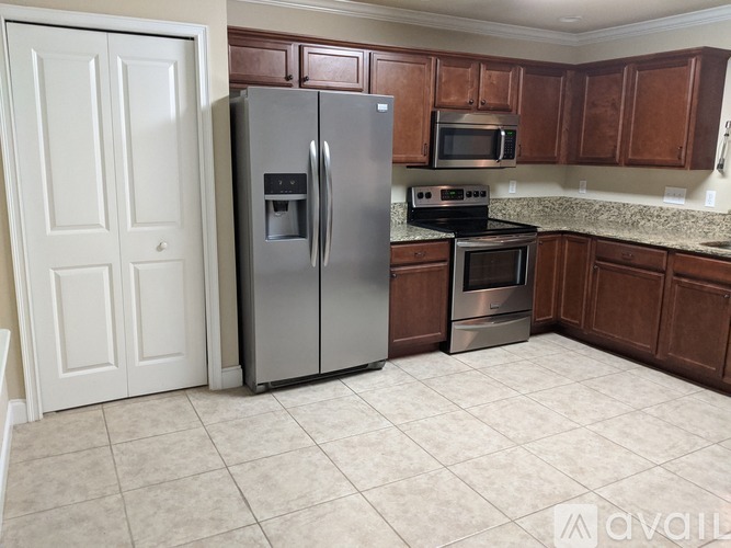 A kitchen with a refrigerator, oven, and microwave.