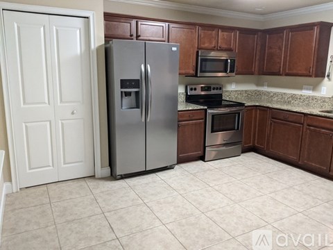 A kitchen with a refrigerator, oven, and microwave.