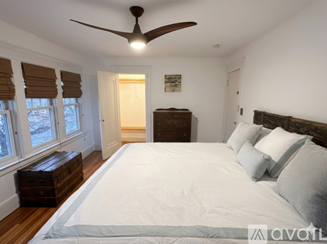 A bedroom with a large bed and a ceiling fan.
