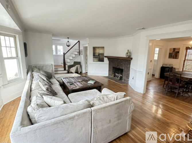 A living room with a large couch and a fireplace.