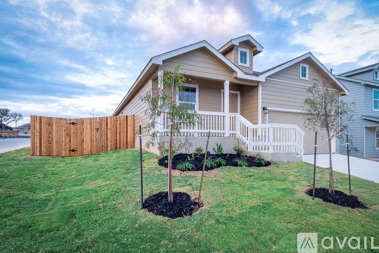 A house with a wooden fence and a small garden in front.