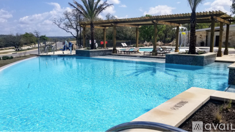 A pool with a wooden deck and a pergola.