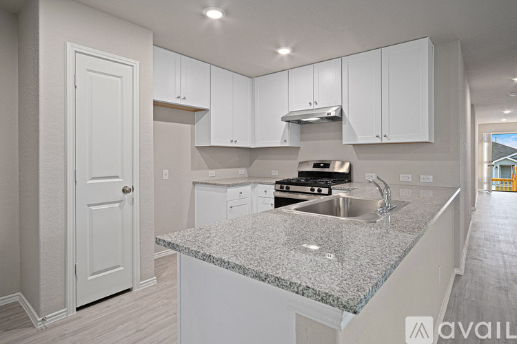 A kitchen with granite countertops and white cabinets.