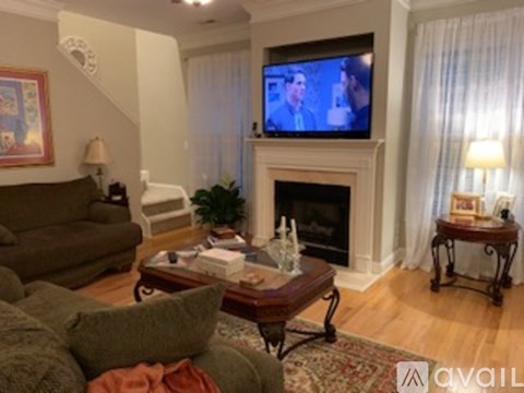 A living room with a fireplace and a television on the wall.