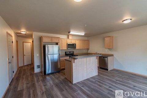 A kitchen with wooden cabinets and a stainless steel refrigerator.