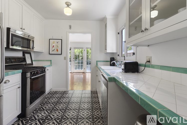 A kitchen with black and white tiles on the floor.