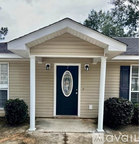 A house with a dark blue door and a circular window above it.