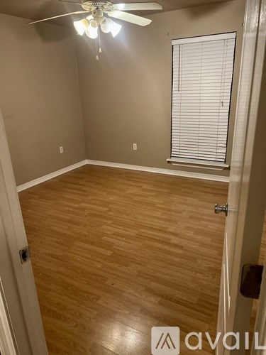 A room with wooden flooring and a ceiling fan.