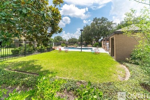 A backyard with a pool and a fence.