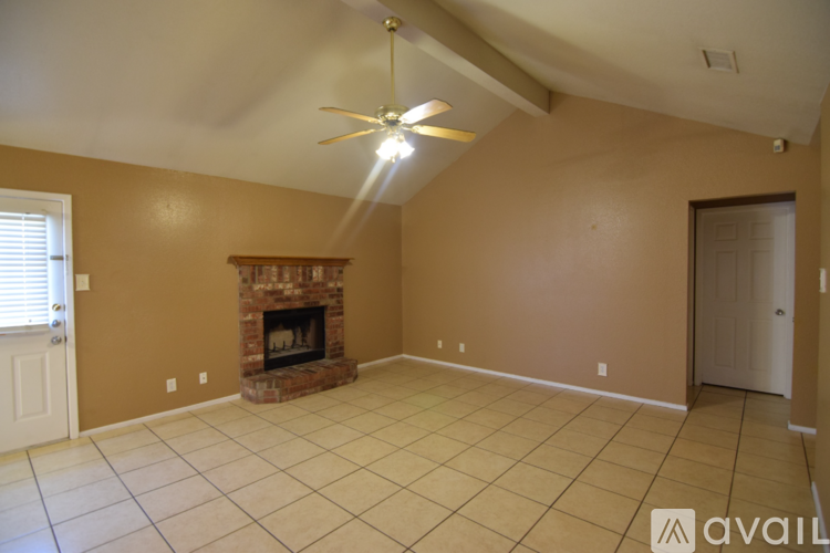 A living room with a fireplace and a ceiling fan.