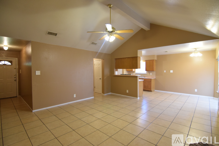 A spacious room with a ceiling fan and tiled flooring.