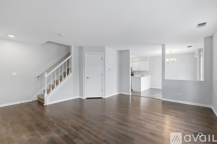 A spacious room with wooden floors and white walls.