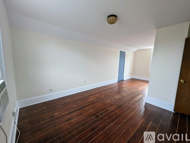 A room with wooden flooring and a white ceiling.