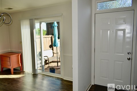A room with a white door and a table with a red object on it.
